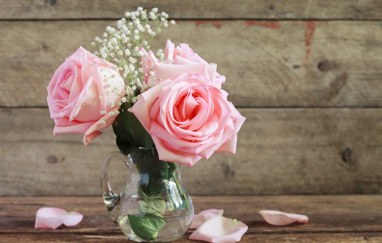 Лепестки розовых роз на столе