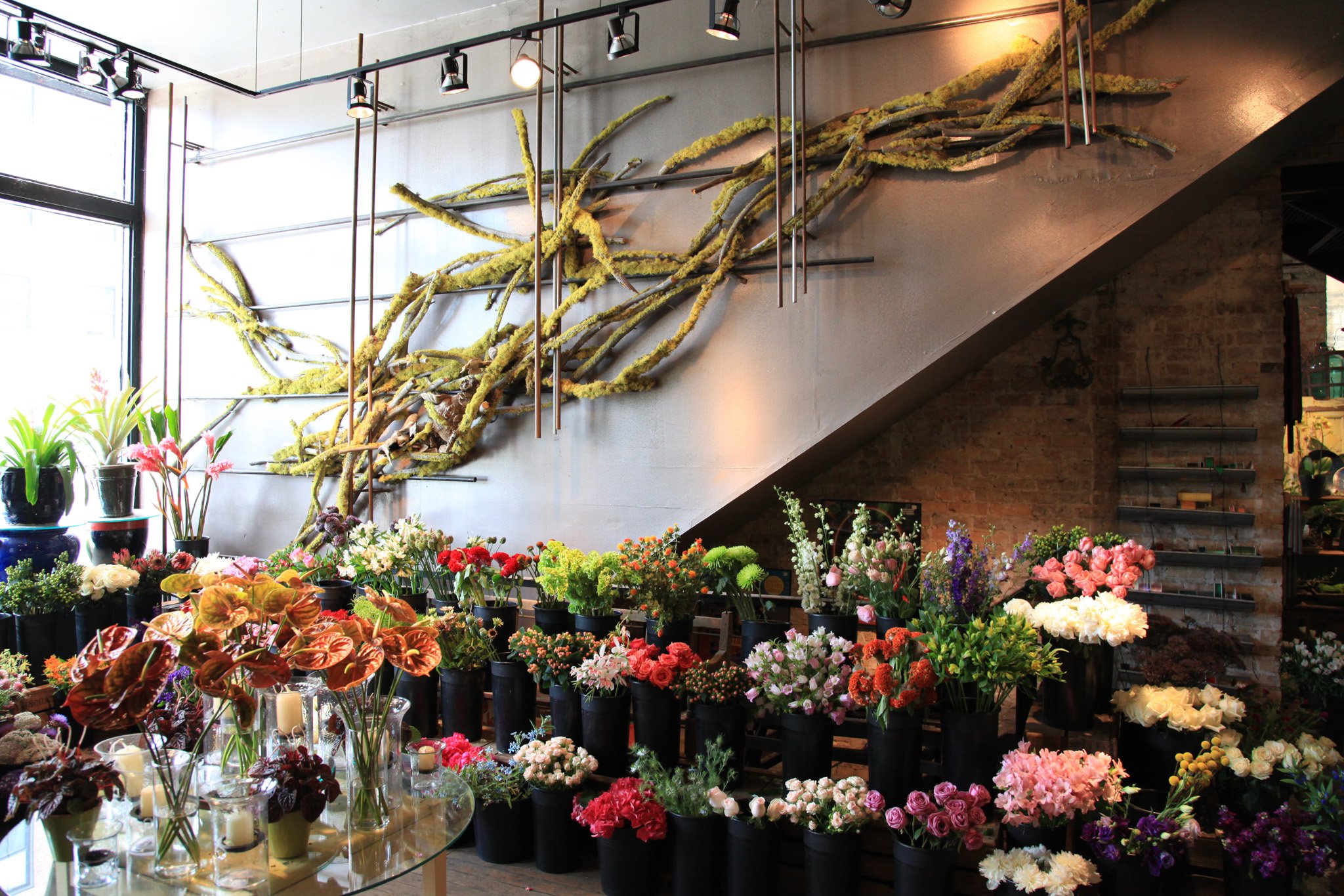 Флористический стол. Декор цветочного магазина. Интерьер цветочного магазина. Украшение цветами. Флорист в магазине цветов.